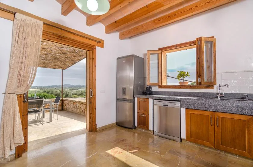 A kitchen with wooden cabinets and a sliding glass door opening onto a patio.