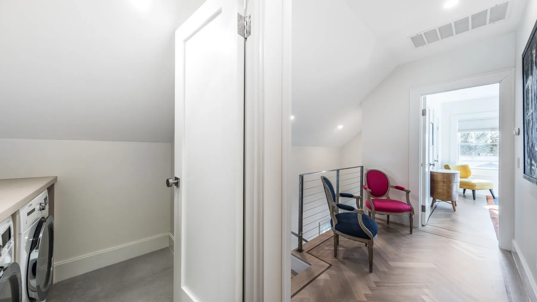 A bright hallway with seating and an open doorway to a sunlit room.
