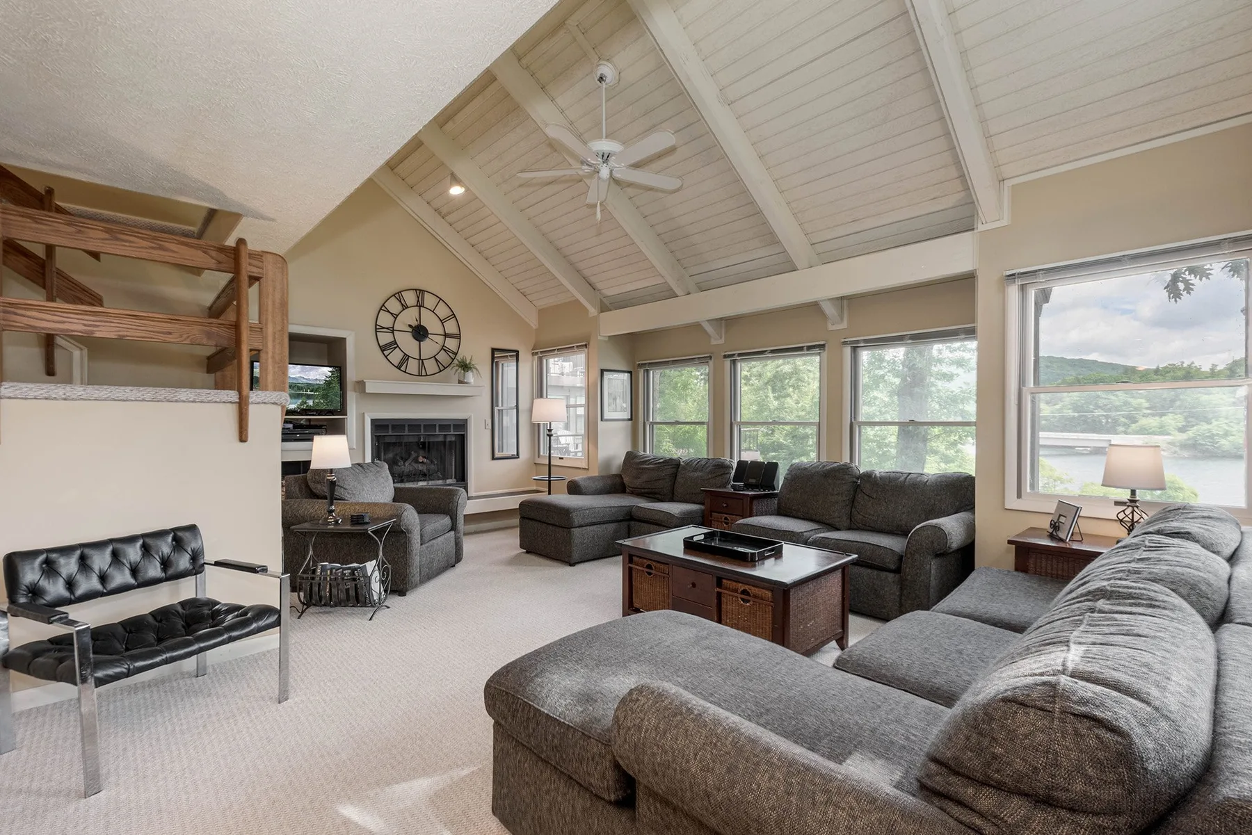 A spacious living room with seating arranged around a coffee table and fireplace.