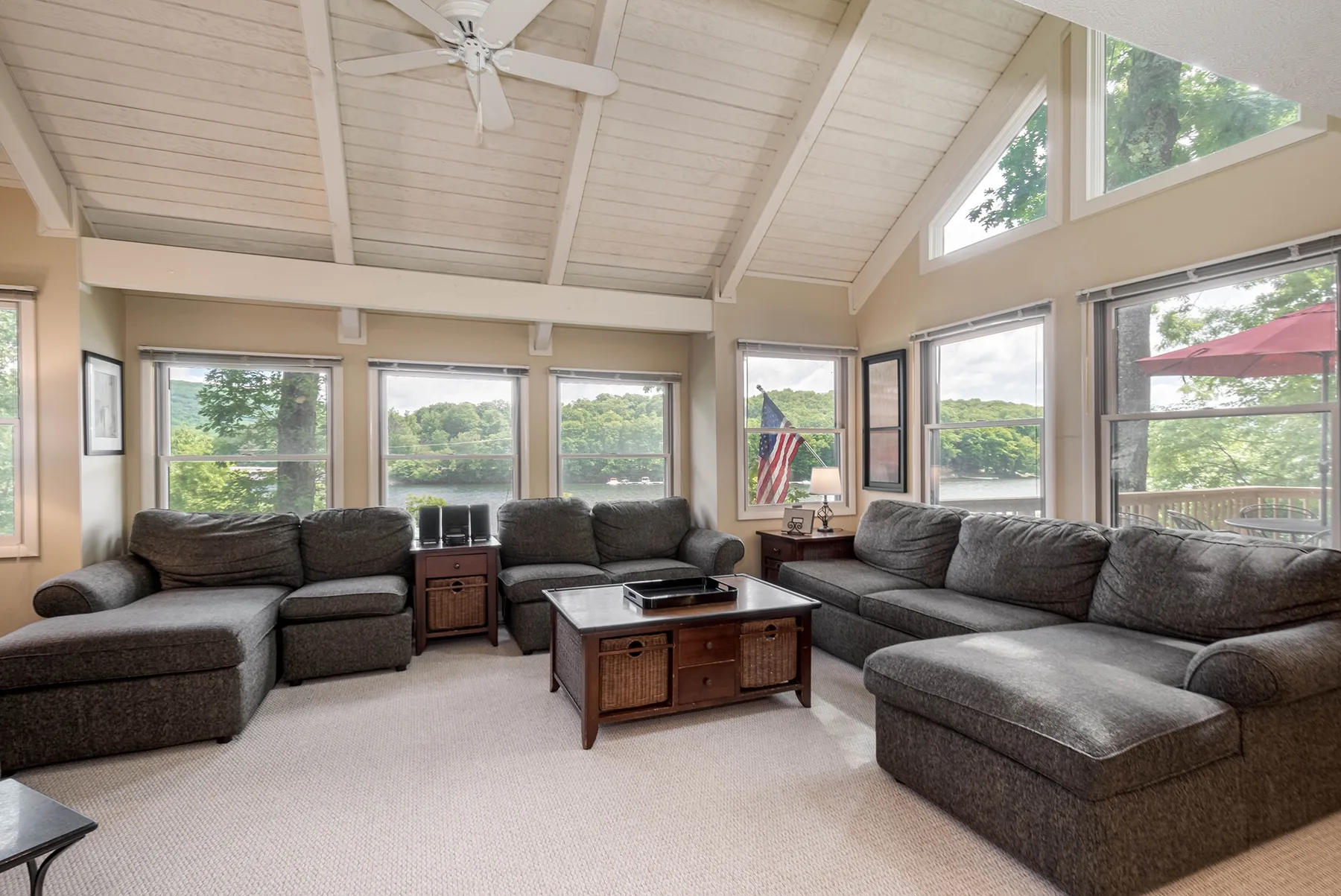 A bright living room with sectional seating, a coffee table, and large windows.