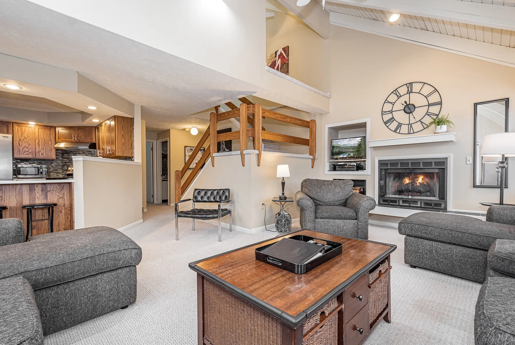 A living room with seating, a coffee table, and a fireplace.