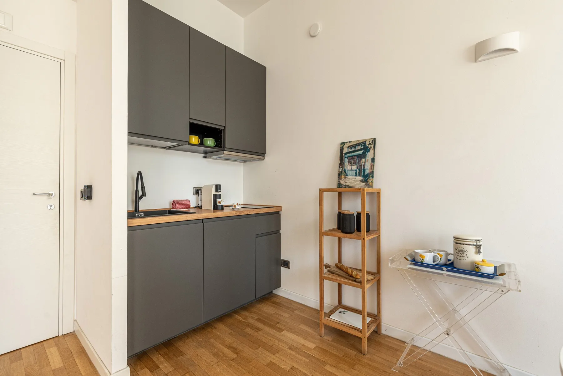 A compact kitchen with dark cabinets, a wooden counter, and a folding table.