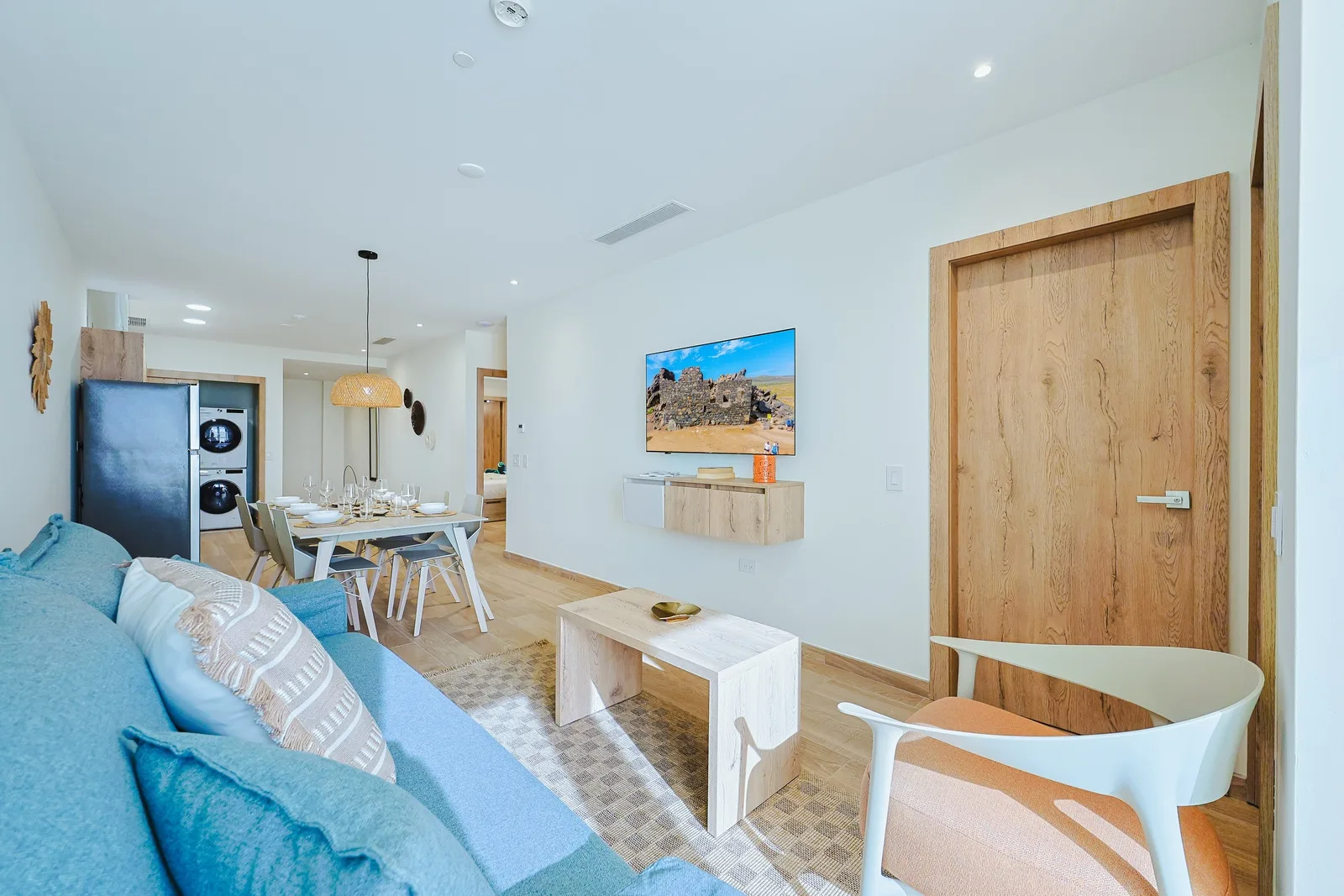 Bright, airy living space with coastal vibes, natural wood accents, and an inviting blue sofa where you can unwind after a day of adventure.