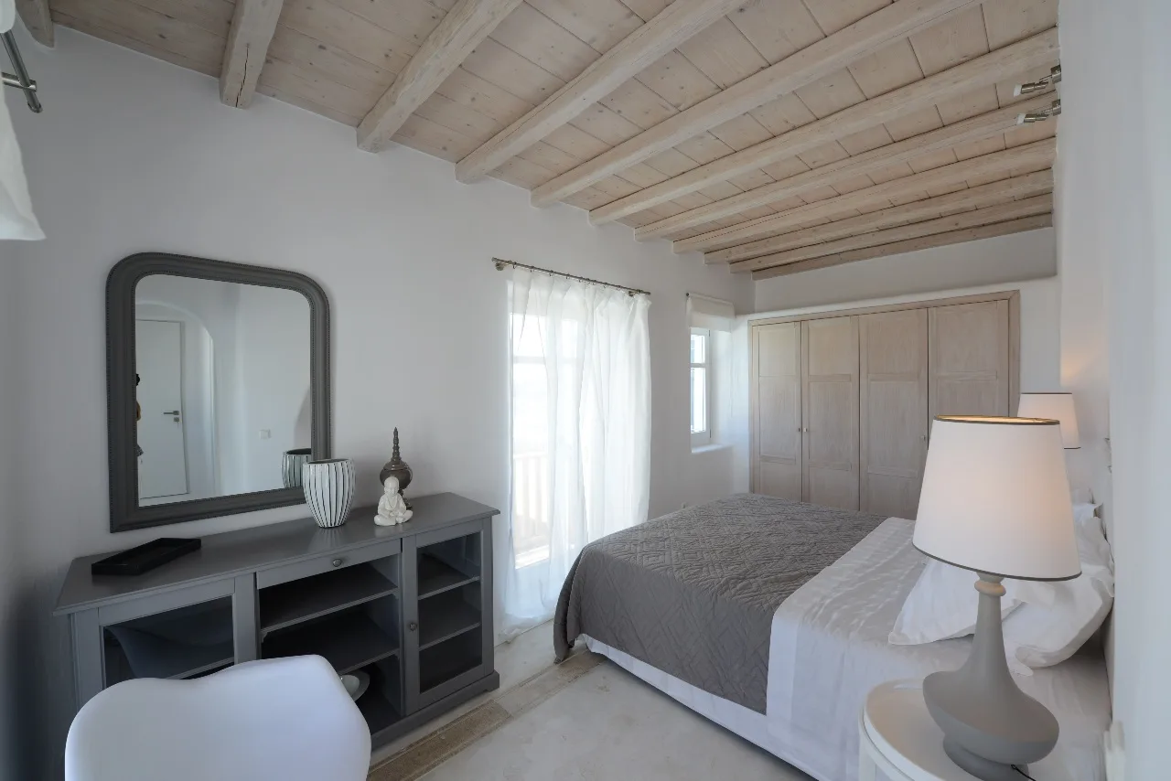 Un dormitorio con una cama, una cómoda y una ventana con cortinas.