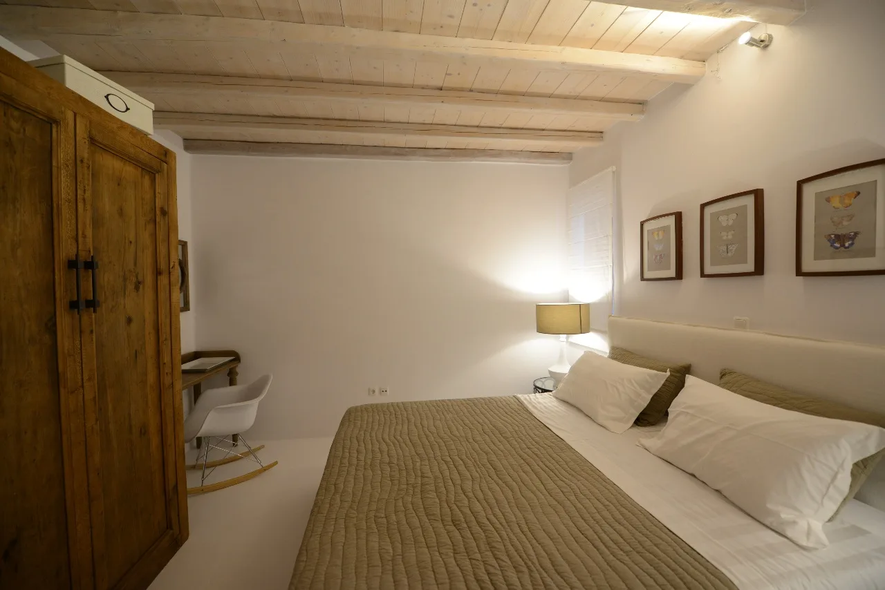 Un dormitorio con una cama grande y un armario de madera.