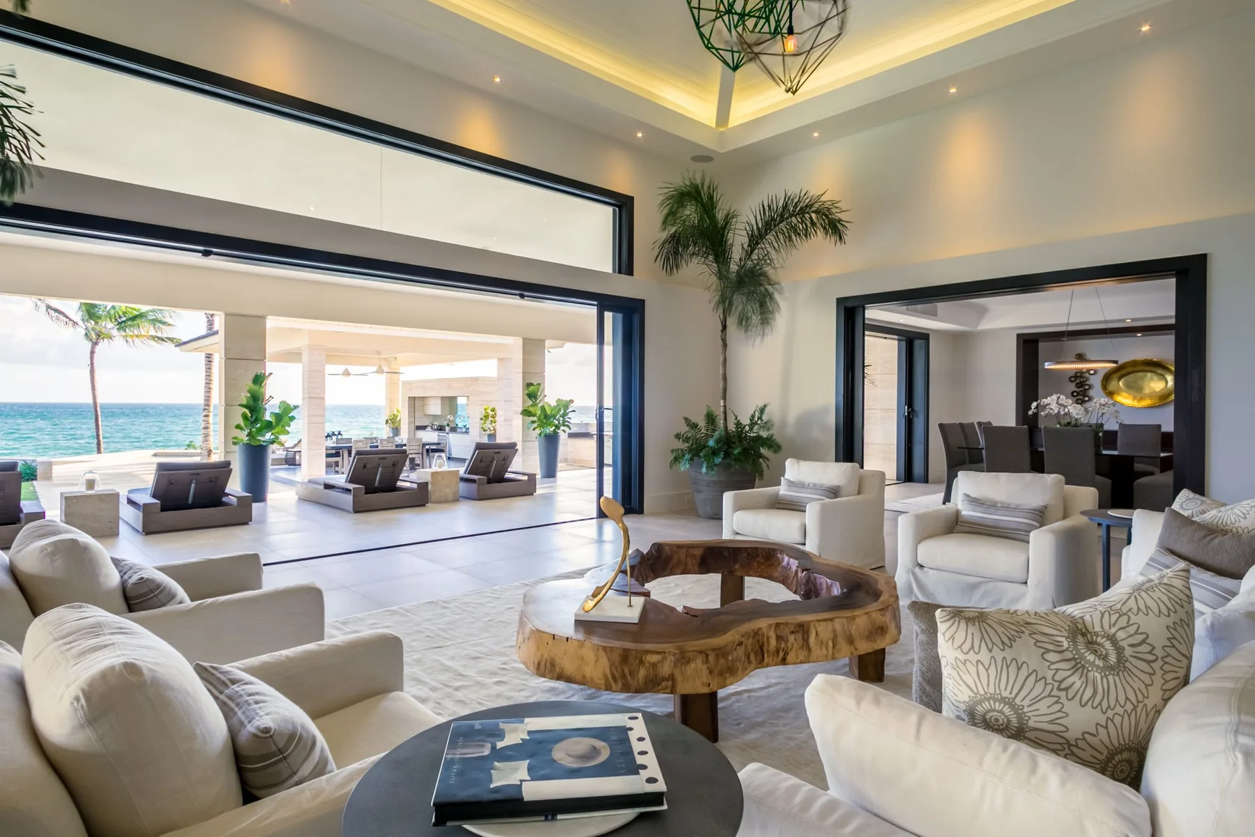 A bright living room opens onto a covered patio overlooking the water.