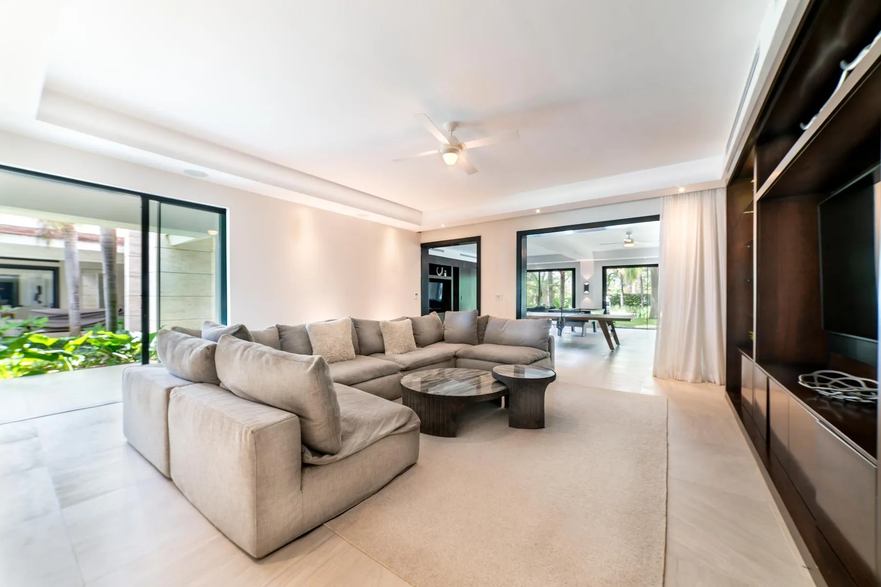 A bright living room with a large sectional seating area and a low coffee table.