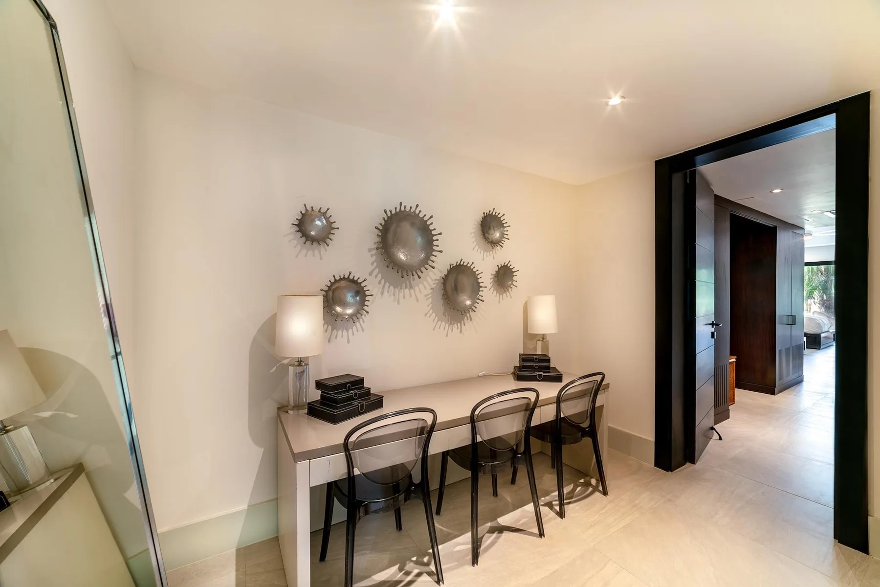 A dining area with a table and chairs beneath decorative wall mirrors.