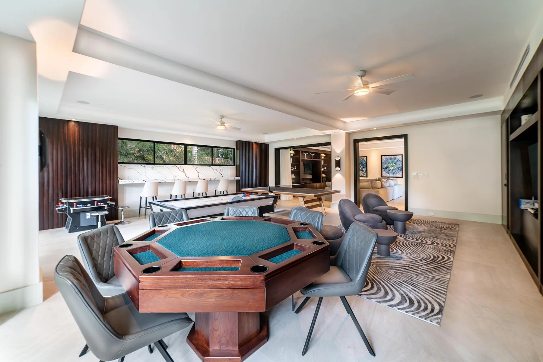 A game room with an octagonal pool table and seating around it.
