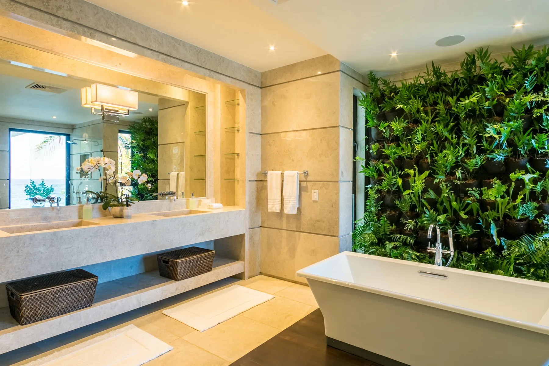 A spacious bathroom features a bathtub, vanity, and lush green wall.