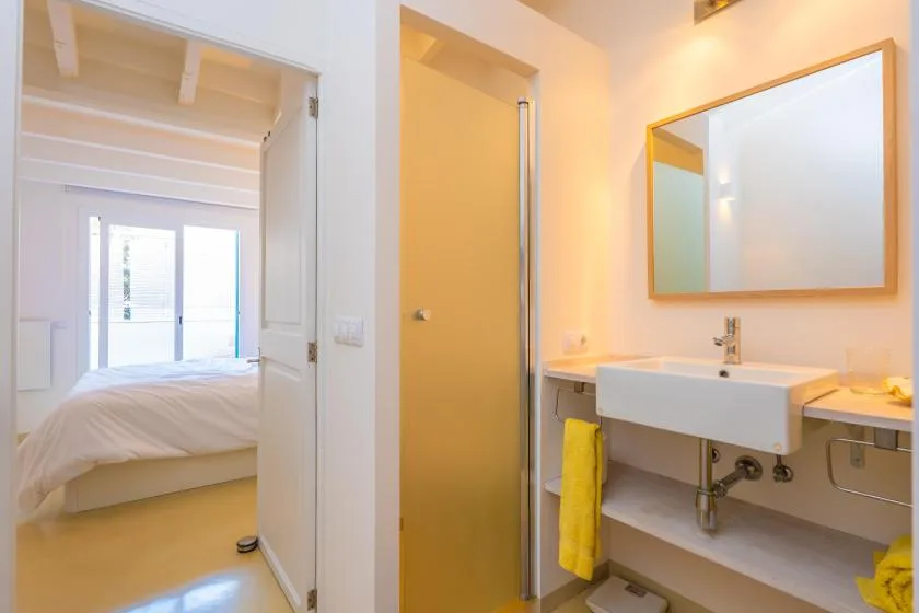 Se ve un dormitorio con una cama junto a un lavabo y un espejo.