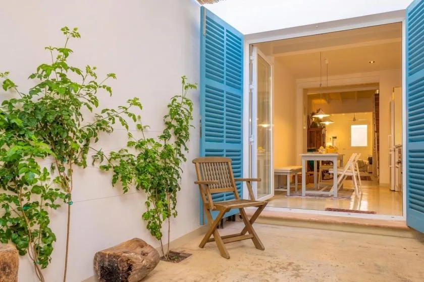 A patio with blue shutters opens onto a warmly lit dining area.