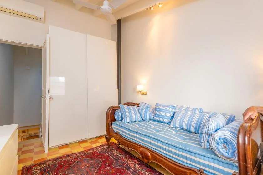 Una sala de estar con asientos de rayas azules y una alfombra estampada.