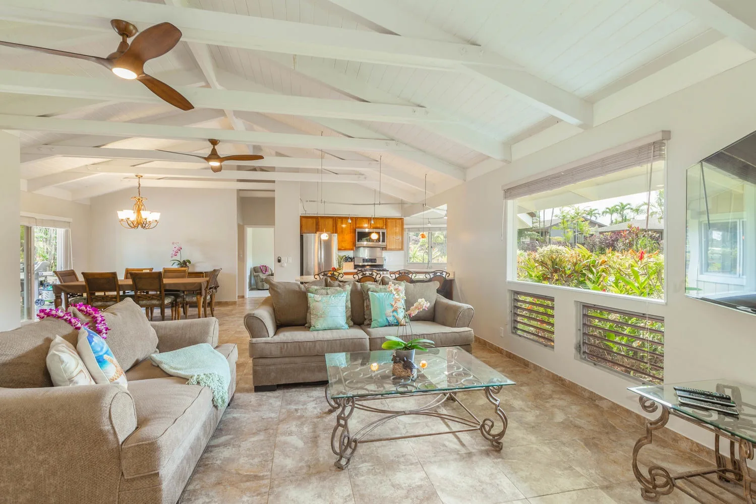 A bright open-plan living and dining area with seating and a glass coffee table.