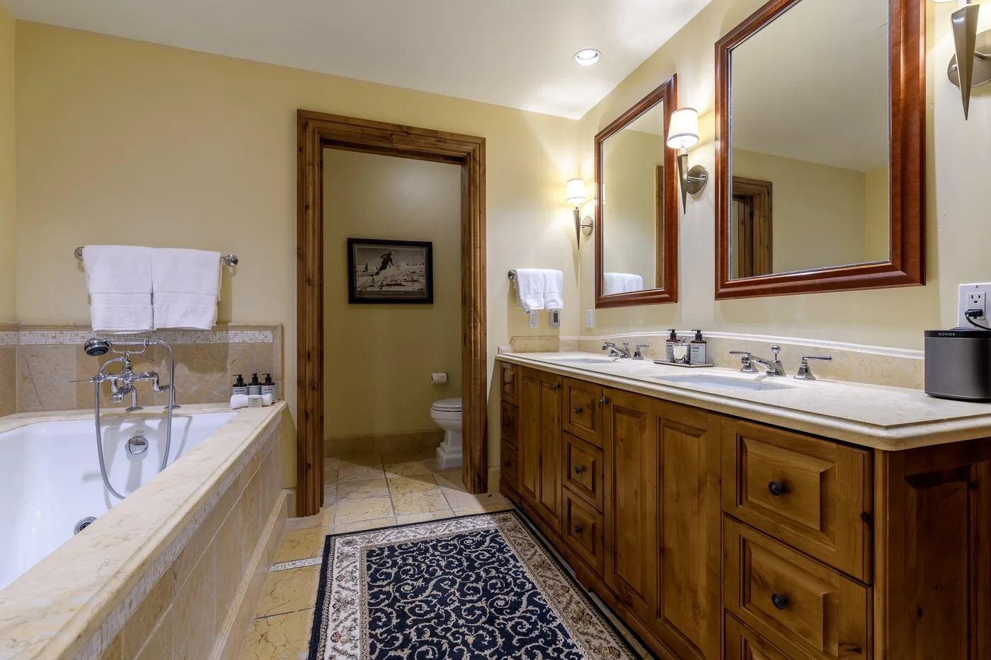 Un baño con bañera, tocador largo y espejos enmarcados.
