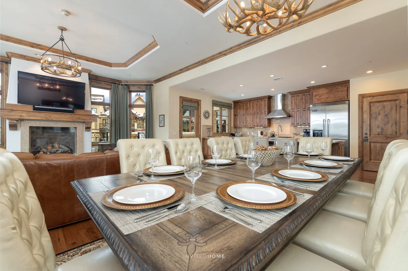 Comedor con la mesa puesta, junto a una sala de estar y una cocina abierta.