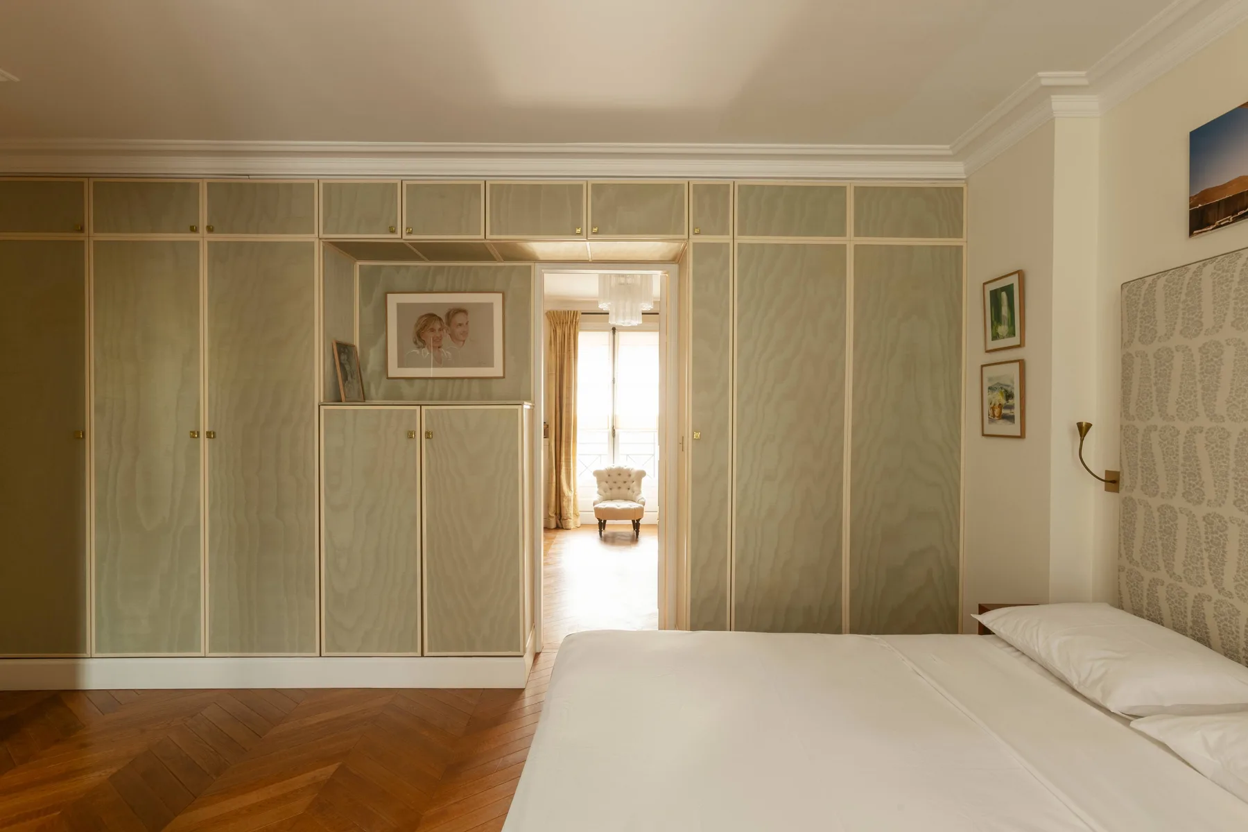 A bedroom with a bed and built-in wardrobes along the wall.