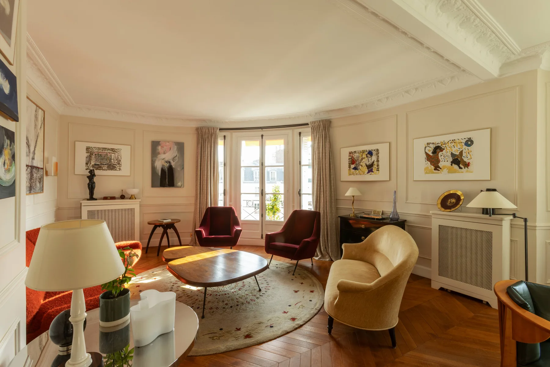 Una sala luminosa con asientos alrededor de una mesa baja y ventanas altas.