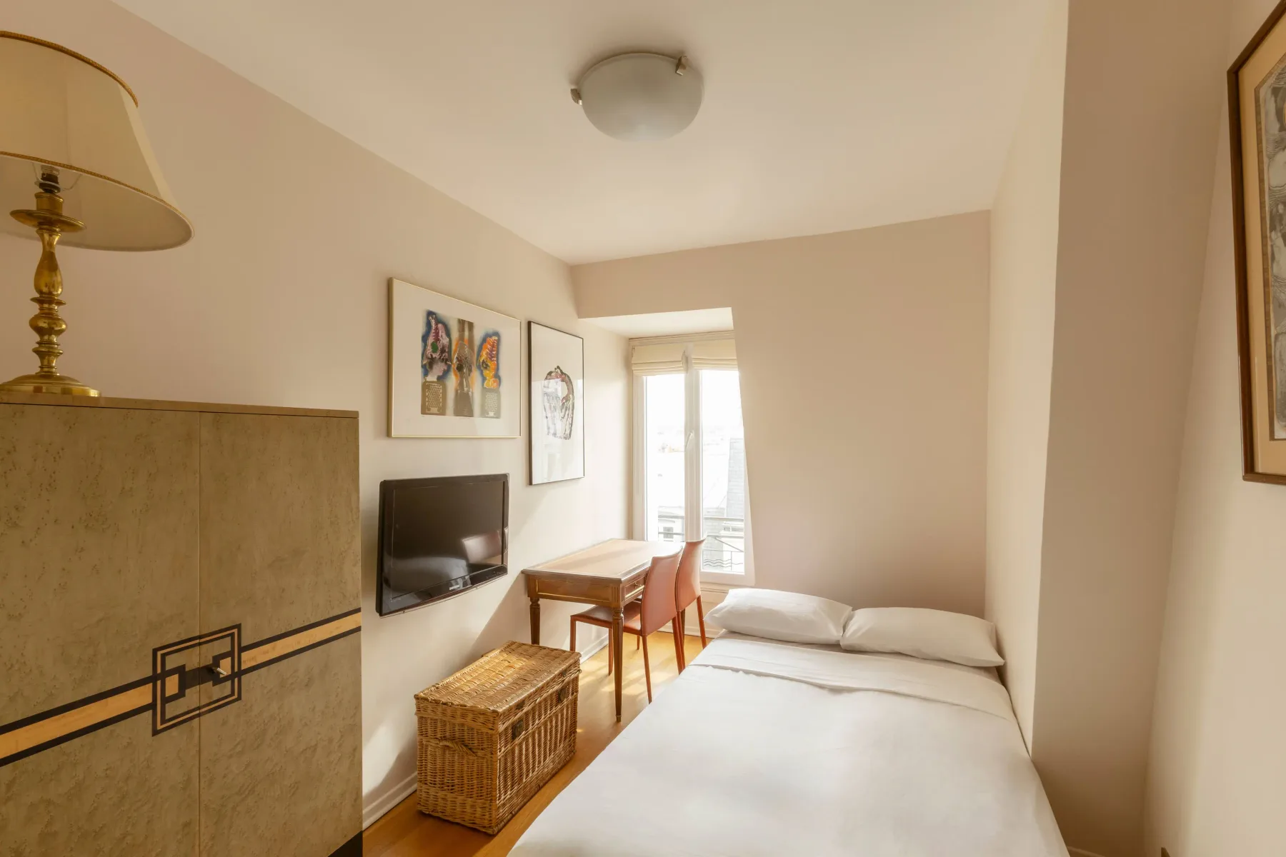 Un dormitorio con una cama, una mesa pequeña y un televisor.