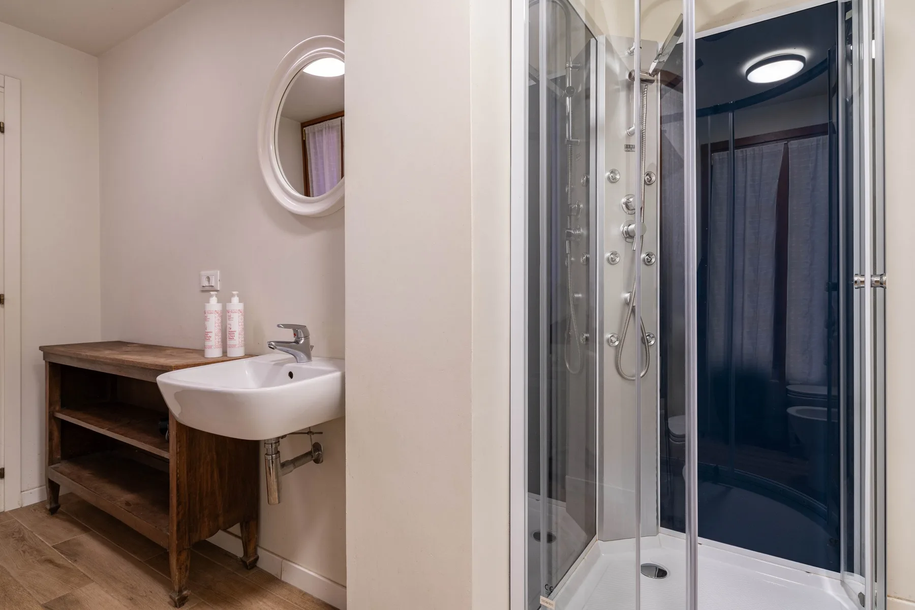 A bathroom with a wall-mounted sink and a glass shower.