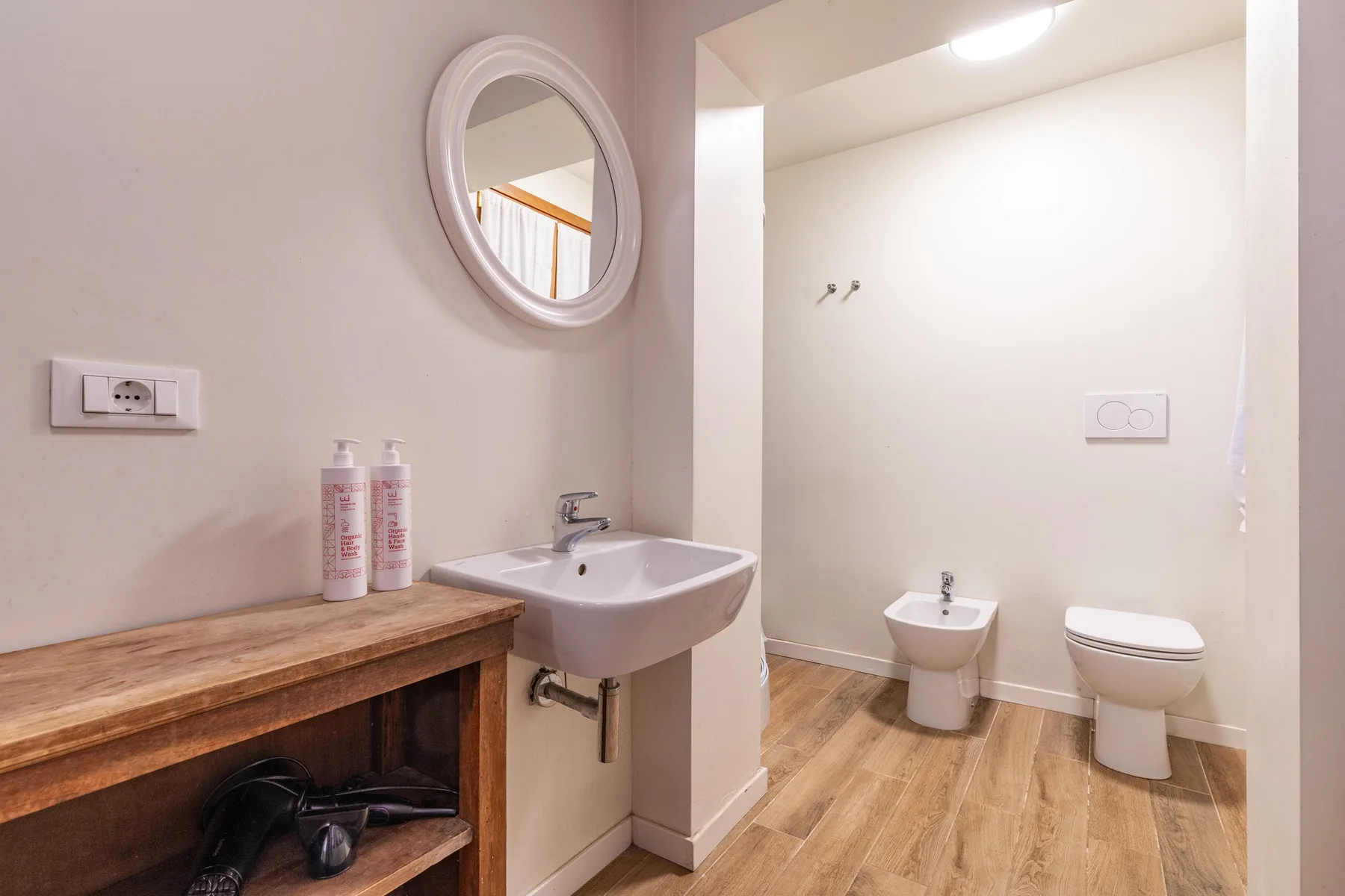 A bright bathroom with a wall-mounted sink and toilet.