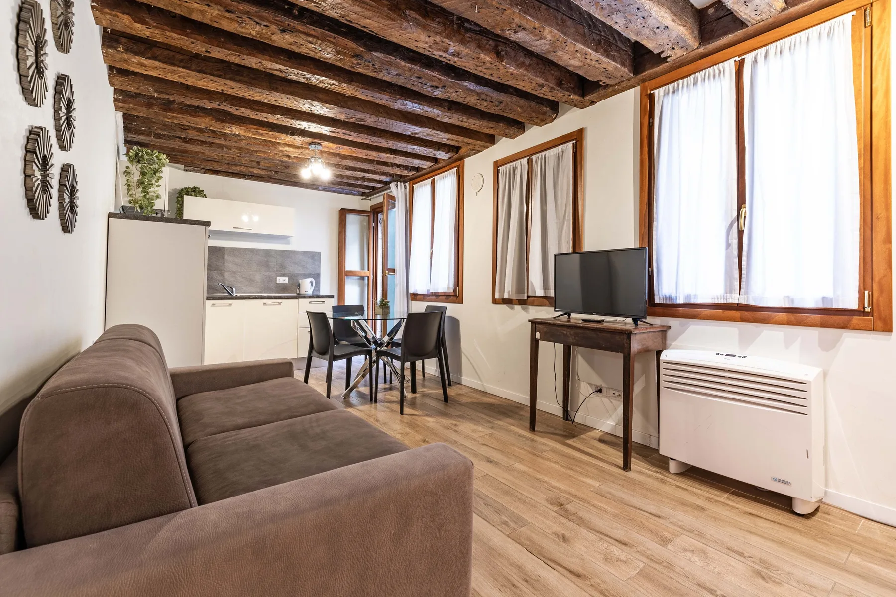 A living area with seating, a television, and a dining table.