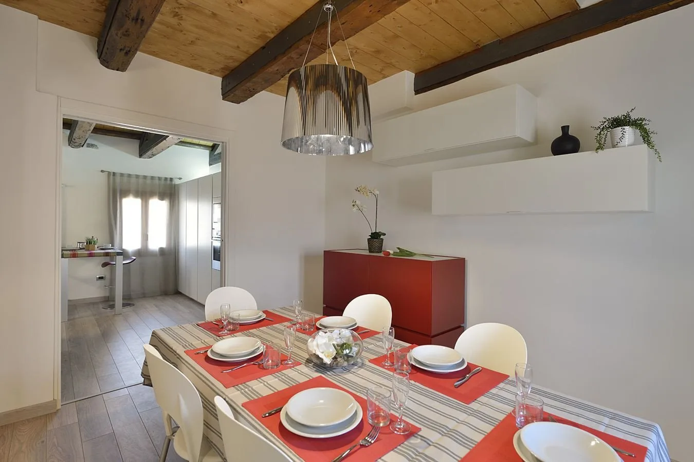 Comedor con la mesa puesta bajo vigas de madera expuestas.