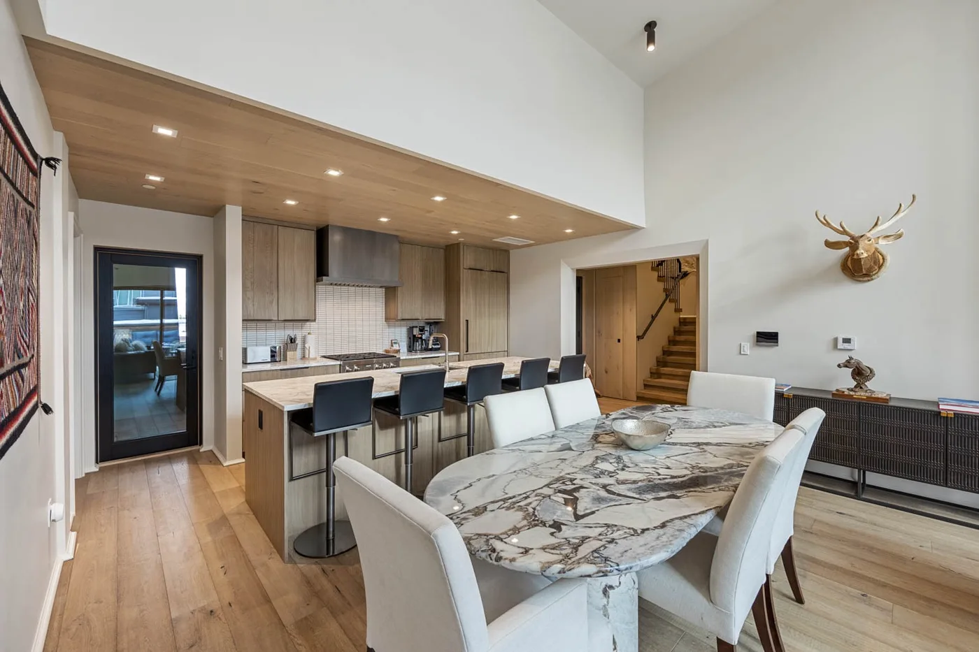 A modern kitchen and dining area with a large marble-patterned table.