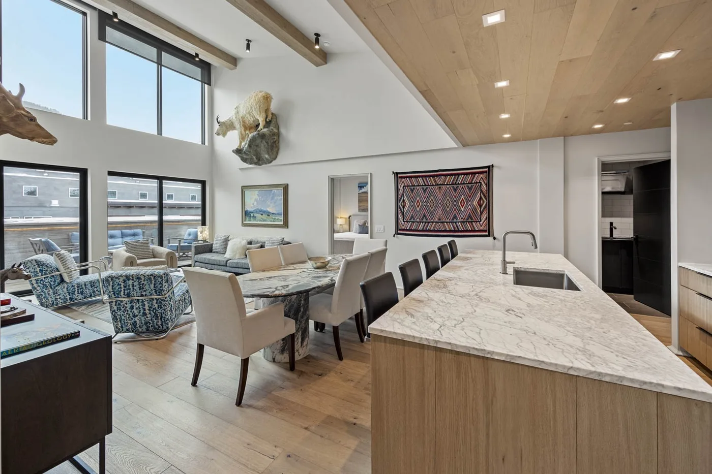 An open-plan kitchen and dining area with a large island beside a living space.