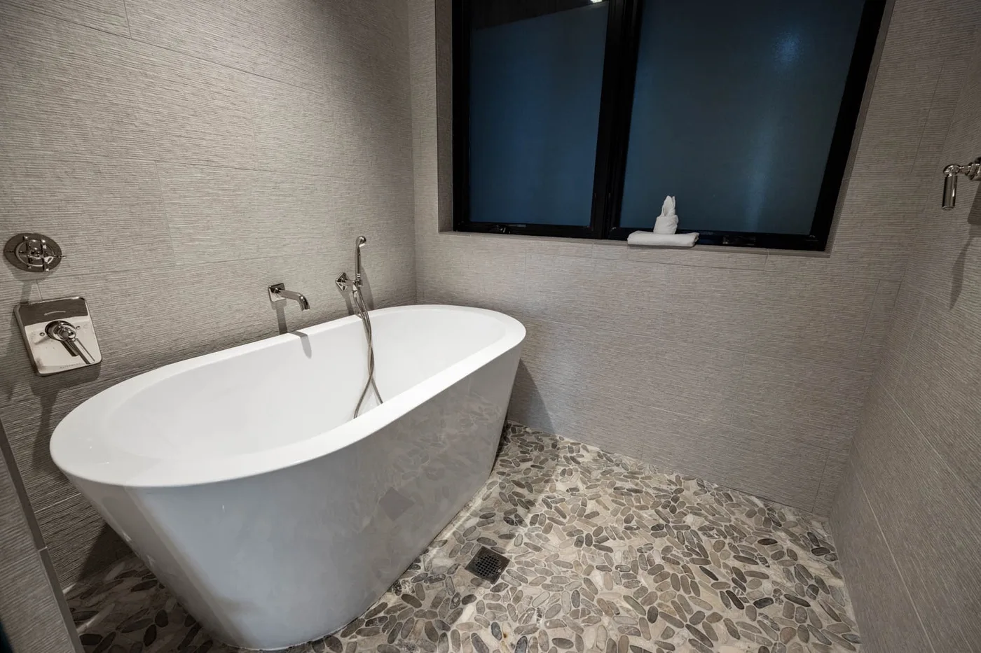 A bathroom with a freestanding bathtub and a window.