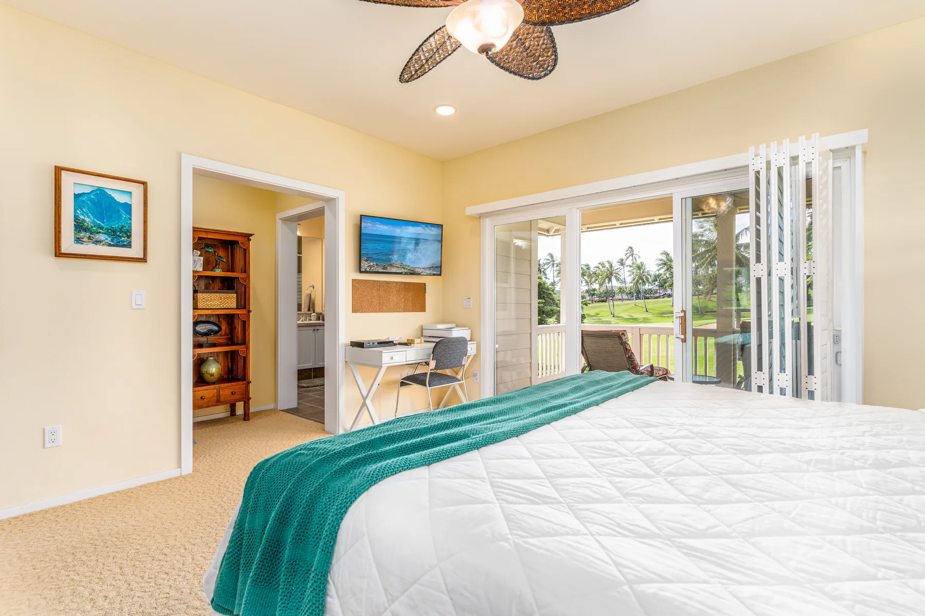 A bedroom with a bed and open doors leading to a balcony.