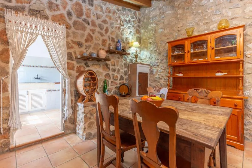 A rustic dining room with a wooden table and a built-in display cabinet.