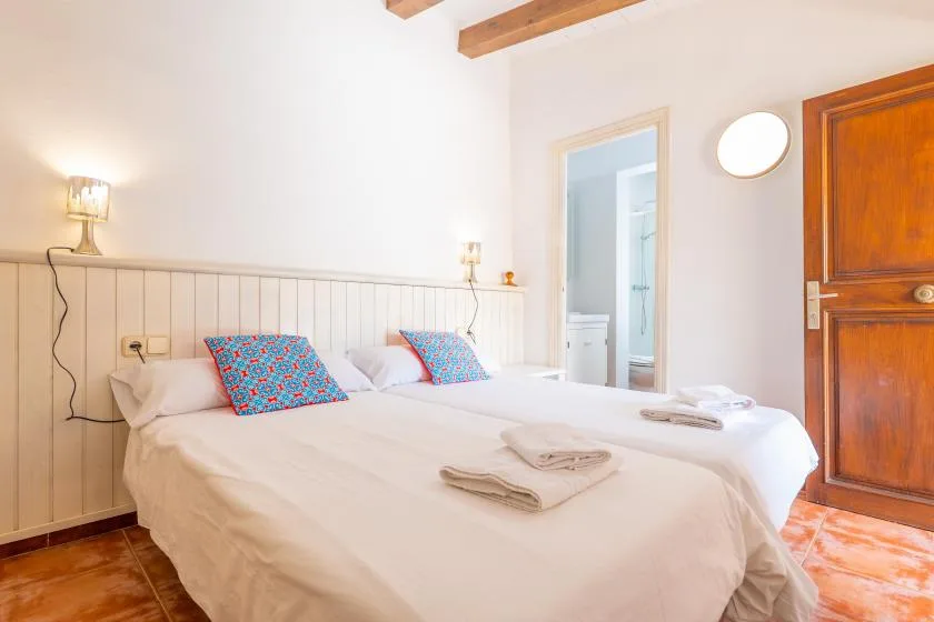 A bright bedroom with a large bed and colorful patterned pillows.