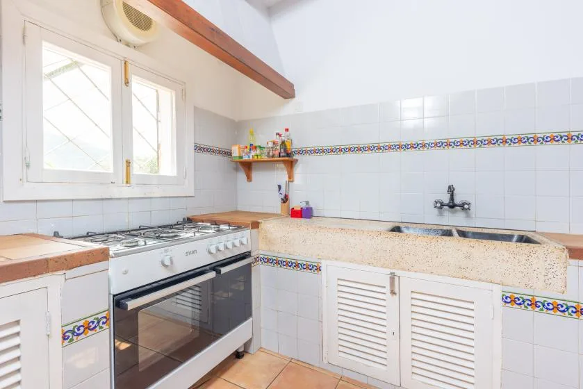 A tiled kitchen with a gas cooktop, oven, and countertop.