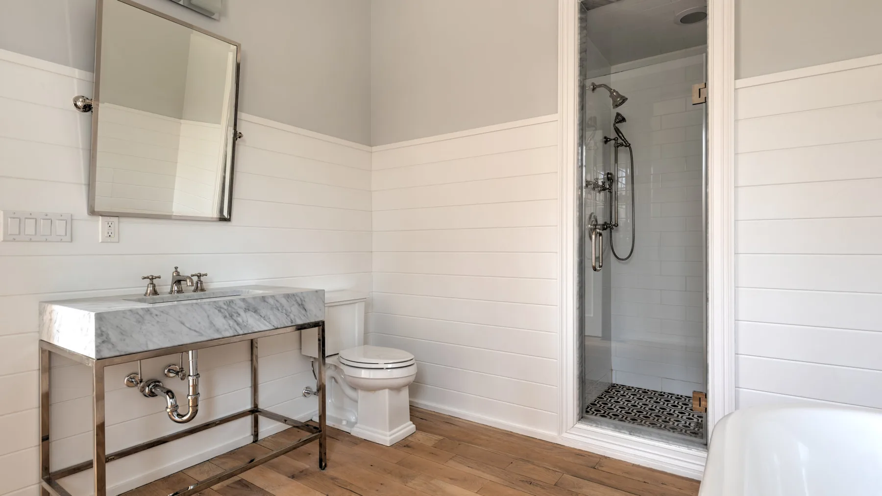 Un baño con lavabo, inodoro y ducha con mampara de vidrio.