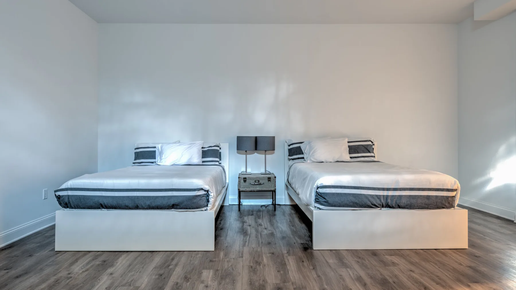 Un dormitorio con dos camas y una mesita entre ellas.
