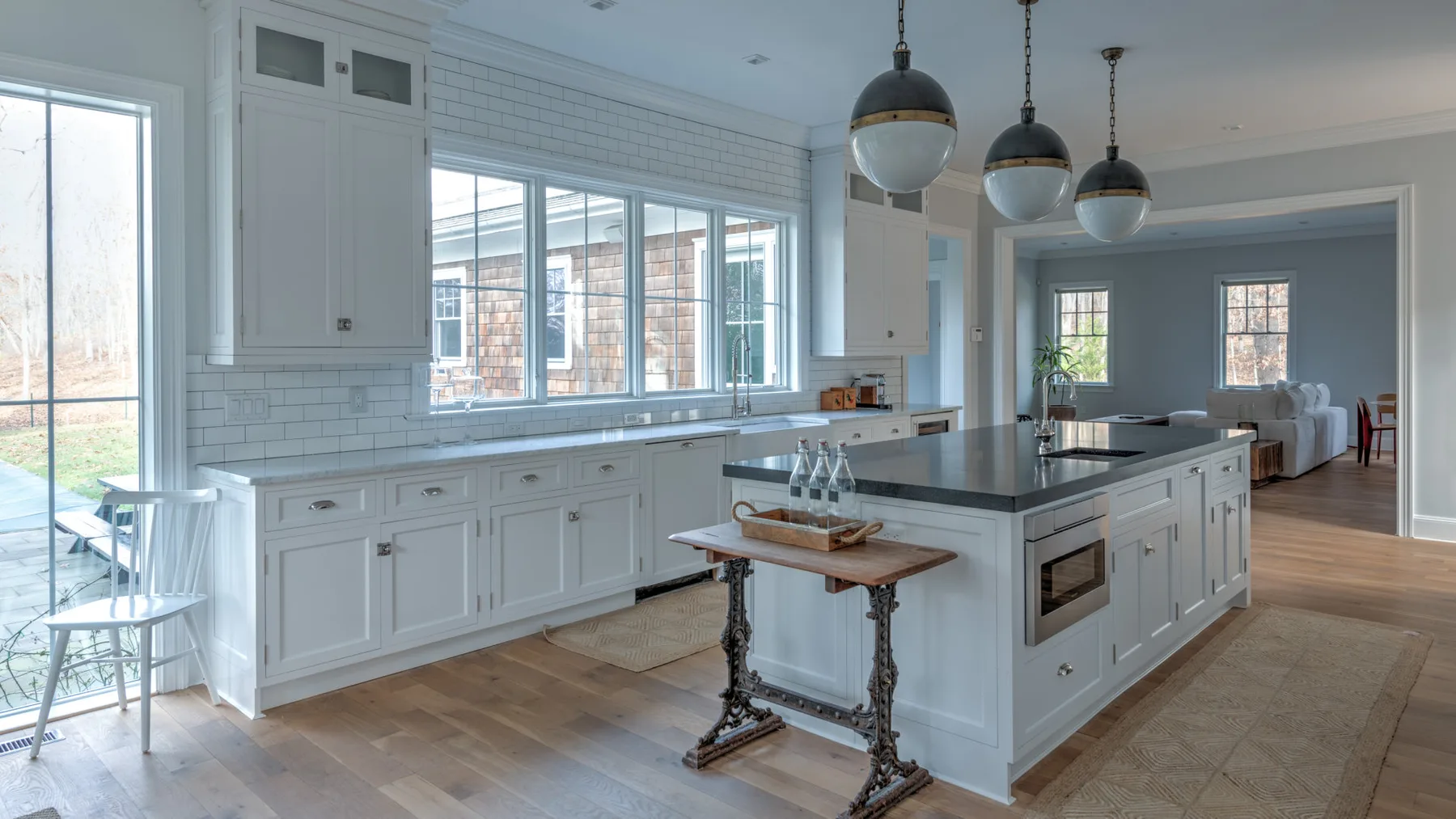Una cocina luminosa con gabinetes blancos, ventanas amplias y una isla central.