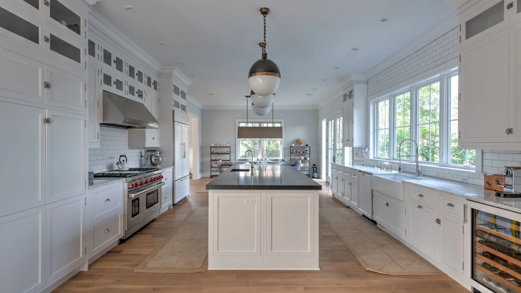 Una cocina luminosa con una isla central y una fila de ventanas grandes.