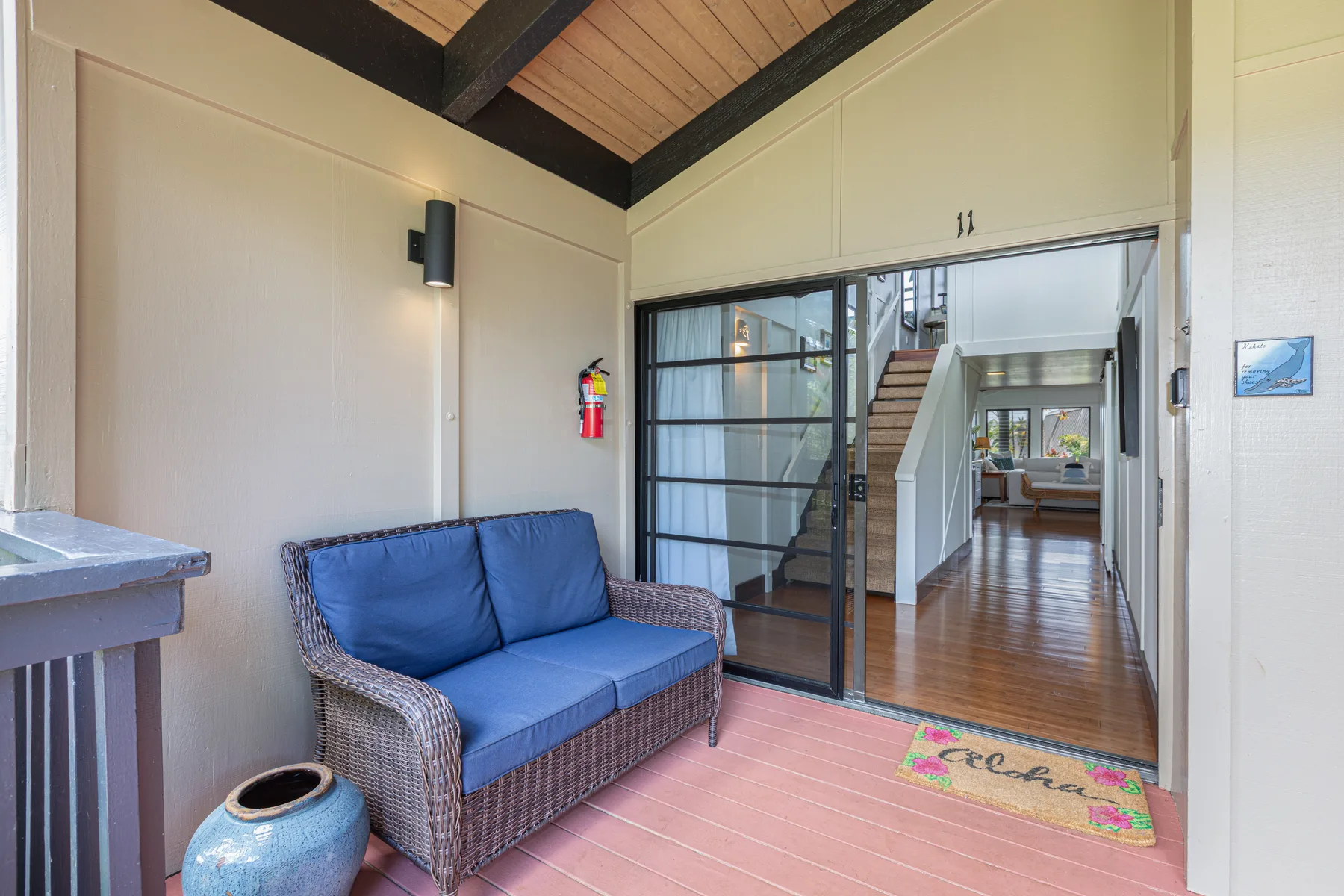 A small sitting area with a blue-cushioned seat beside a glass doorway.