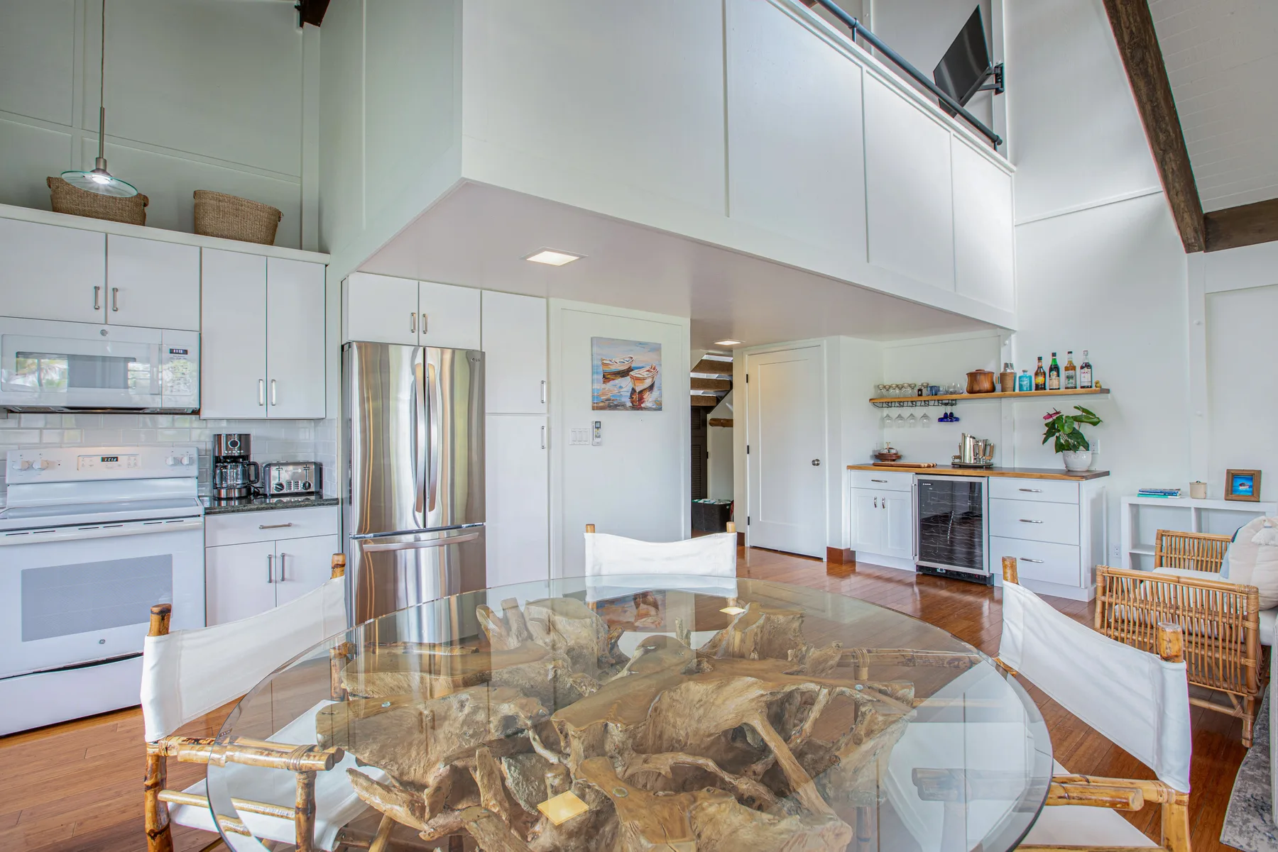 A bright open-plan kitchen and dining area with a large glass dining table.