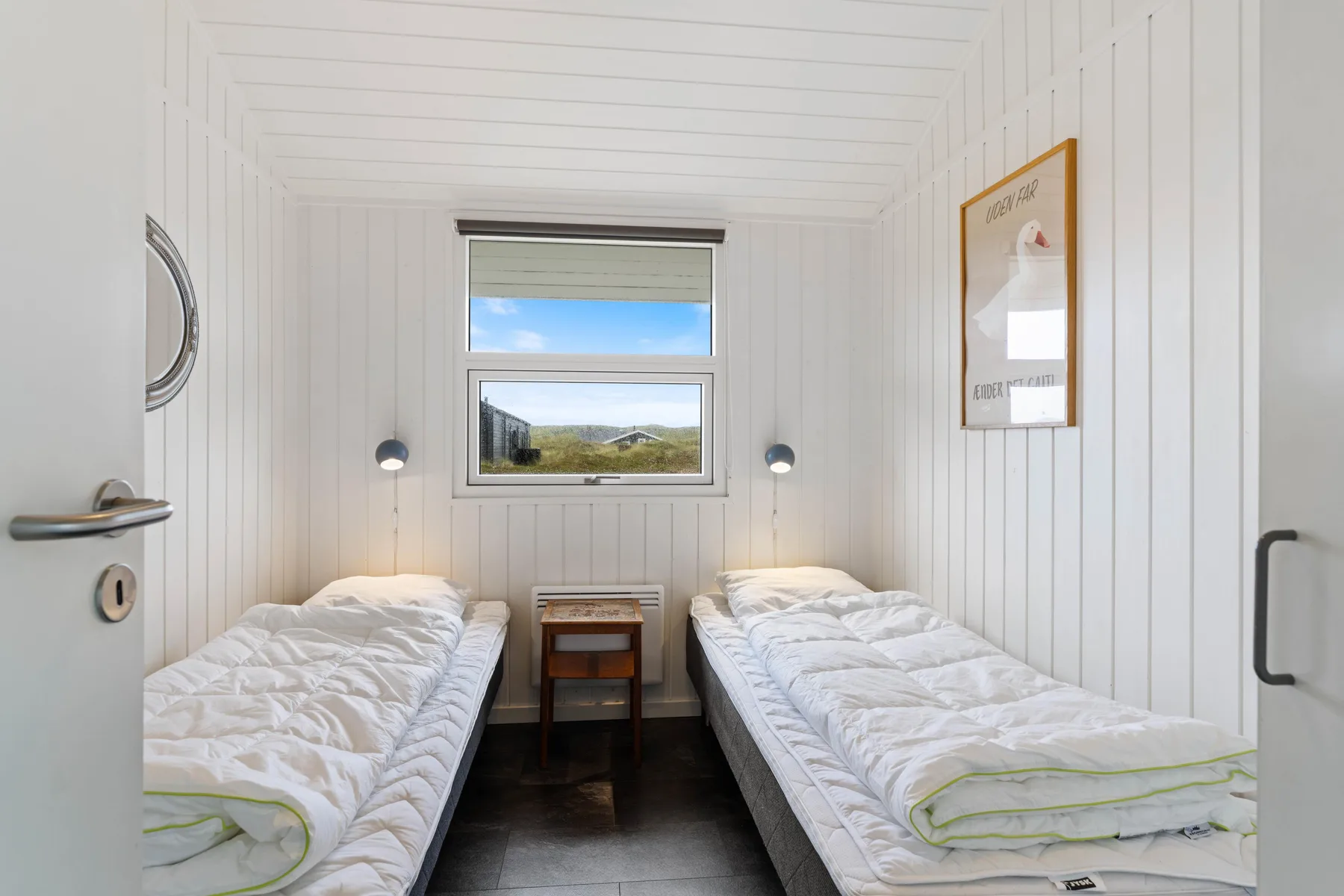 Dormitorio con dos camas individuales y una ventana con vistas al paisaje.