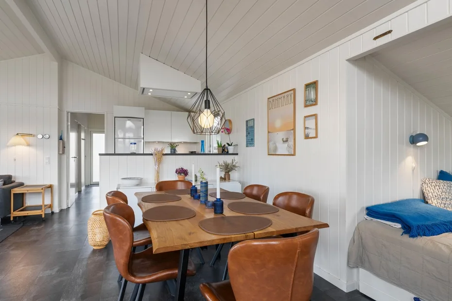 Comedor con una mesa de madera y sillas junto a una cocina compacta.