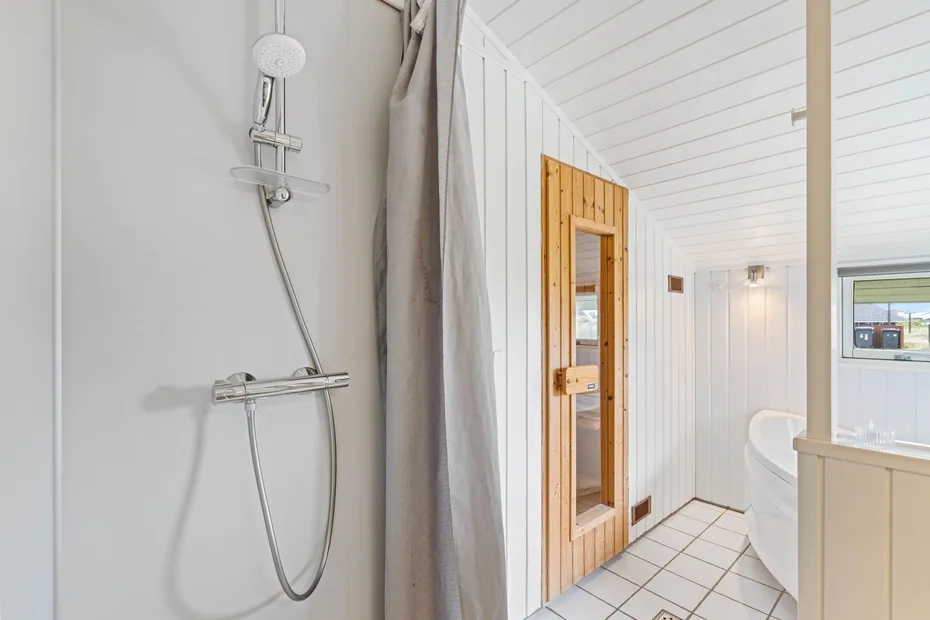 Un baño luminoso con ducha, bañera y una puerta con marco de madera.