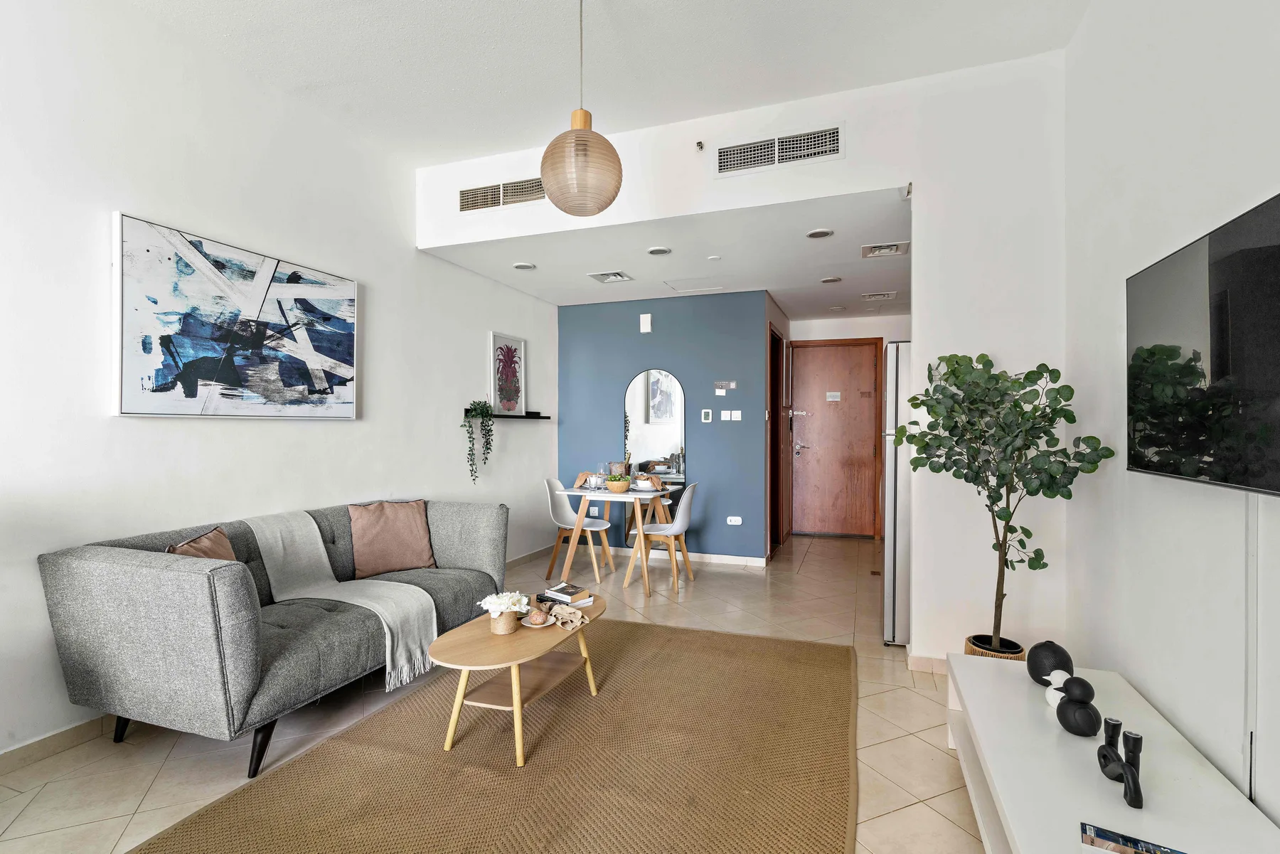 Una sala luminosa con sofá, mesa de centro y zona de comedor.