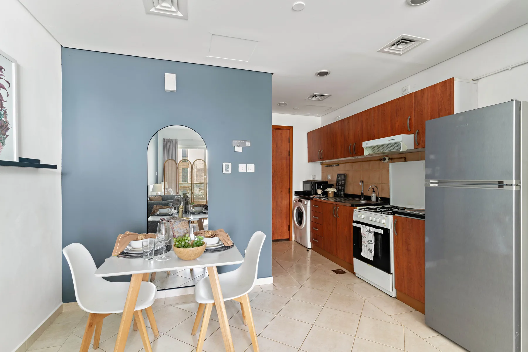 Comedor con mesa y sillas junto a una cocina con gabinetes de madera.