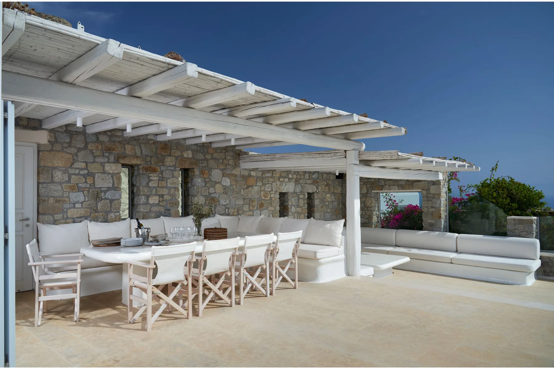 Una zona de comedor exterior cubierta con una mesa larga y asientos integrados.