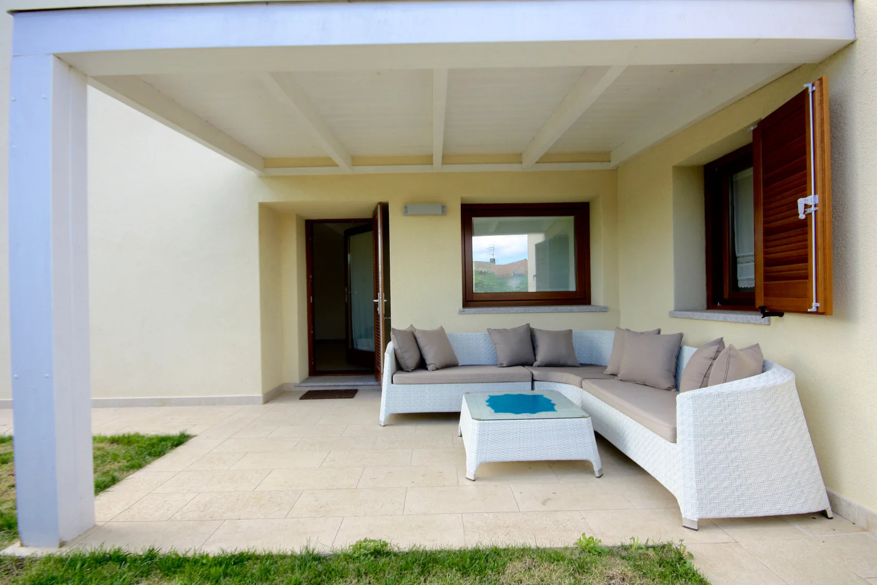 Un patio cubierto con asientos al aire libre y una mesa baja.