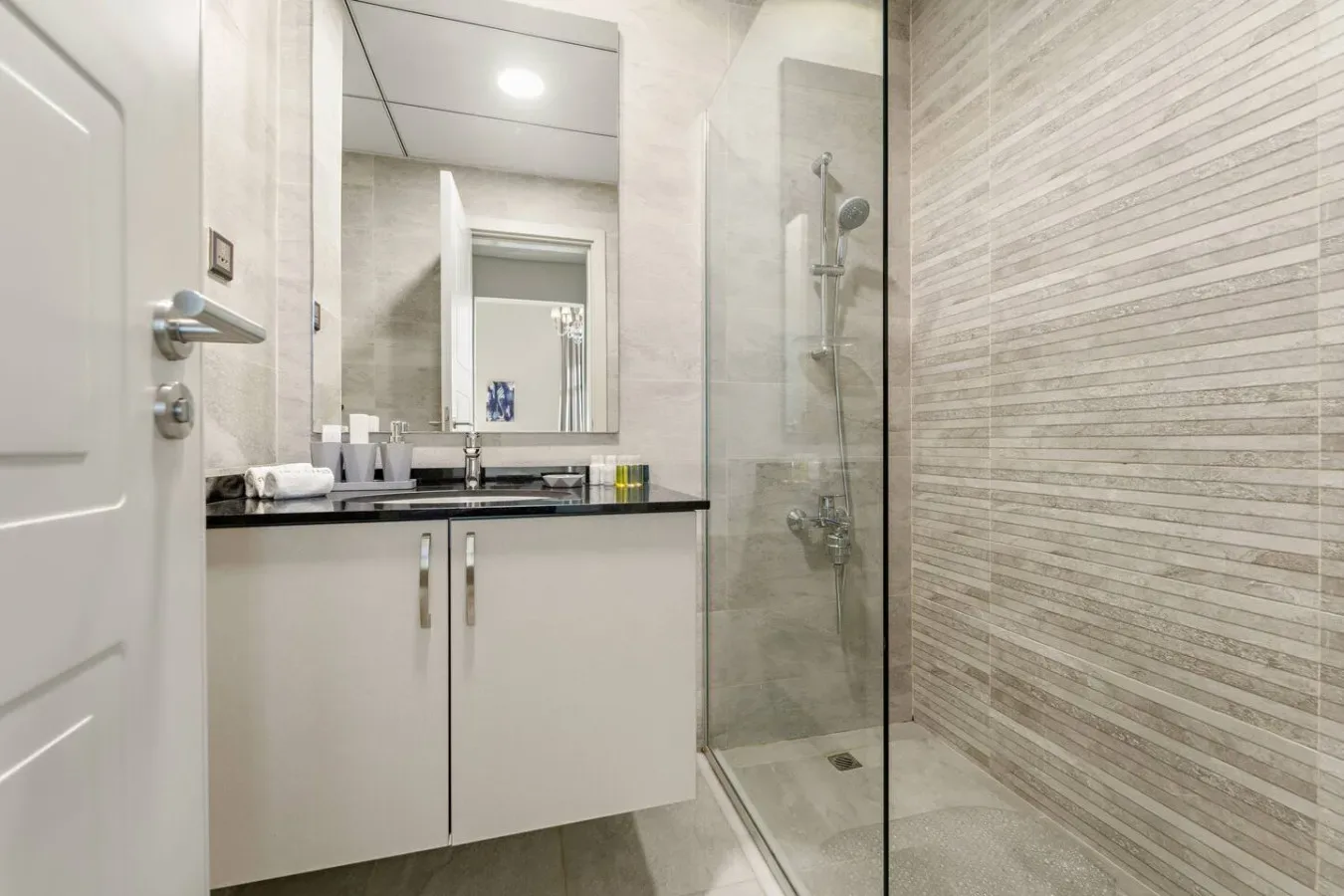 Un baño con lavabo y ducha de vidrio.