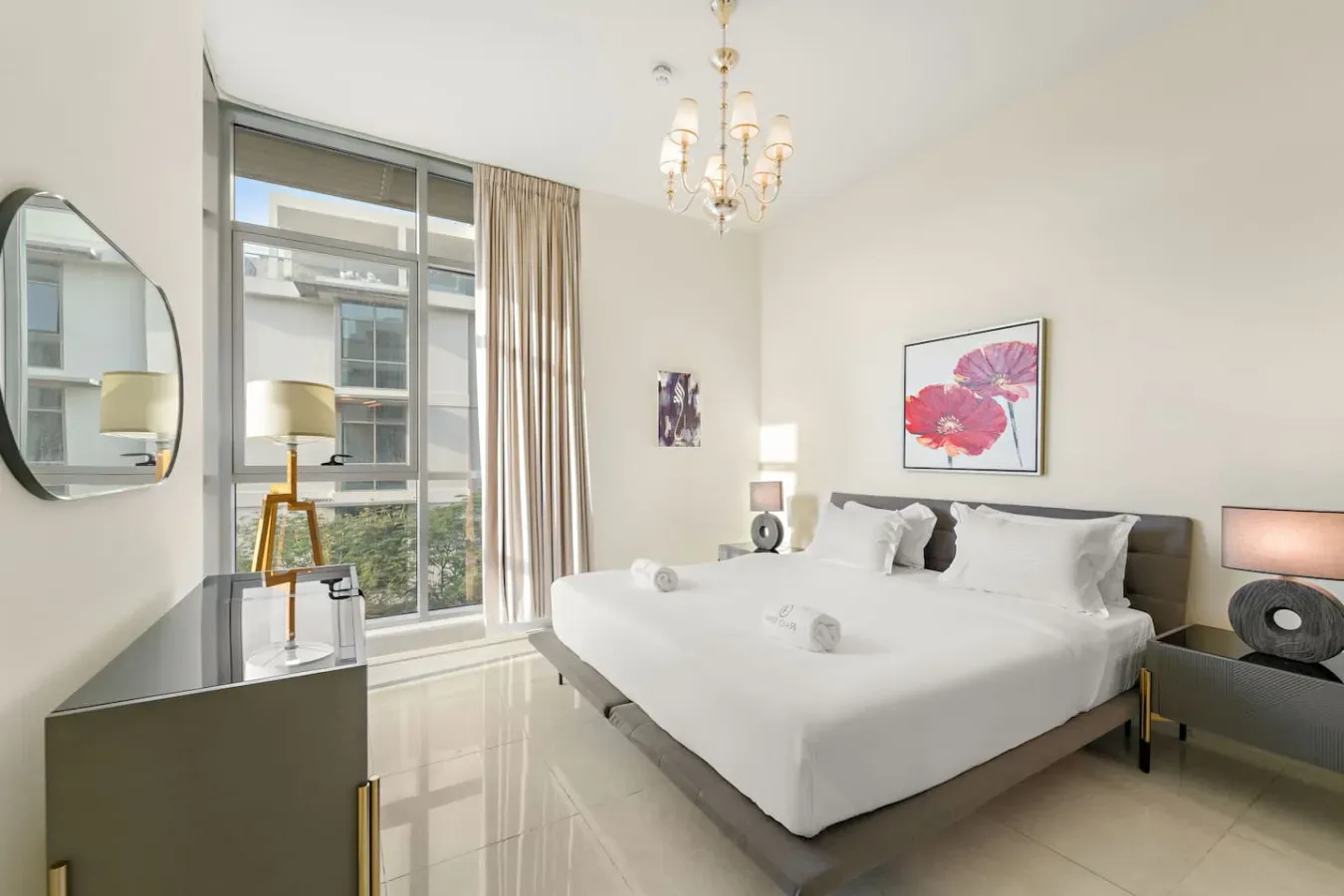 Un dormitorio luminoso con una cama grande junto a una ventana de piso a techo.