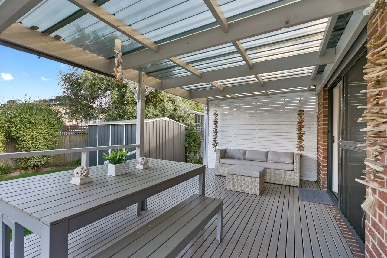 A covered outdoor patio with seating and a table.